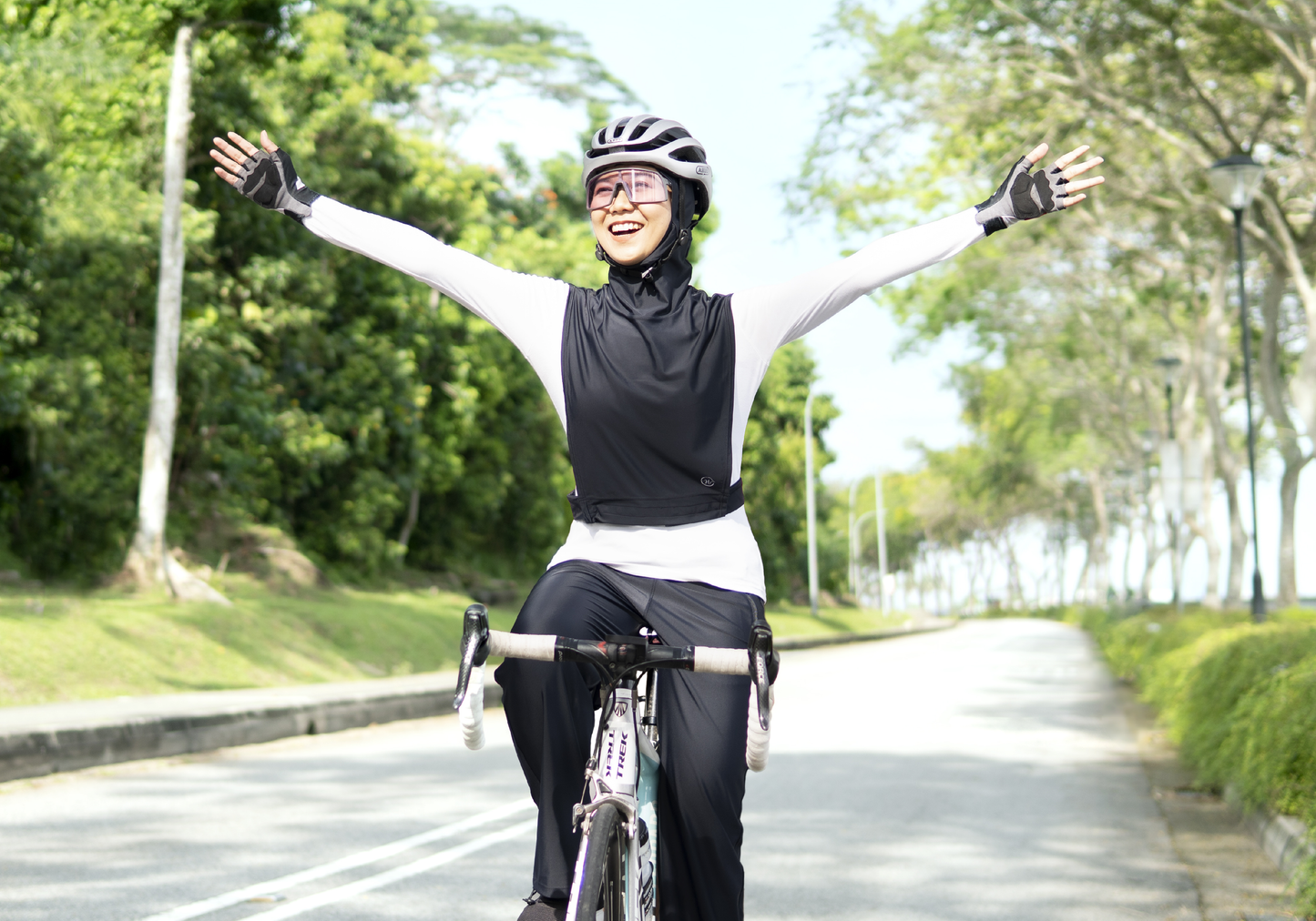 Lady enjoying her bike ride along a green path