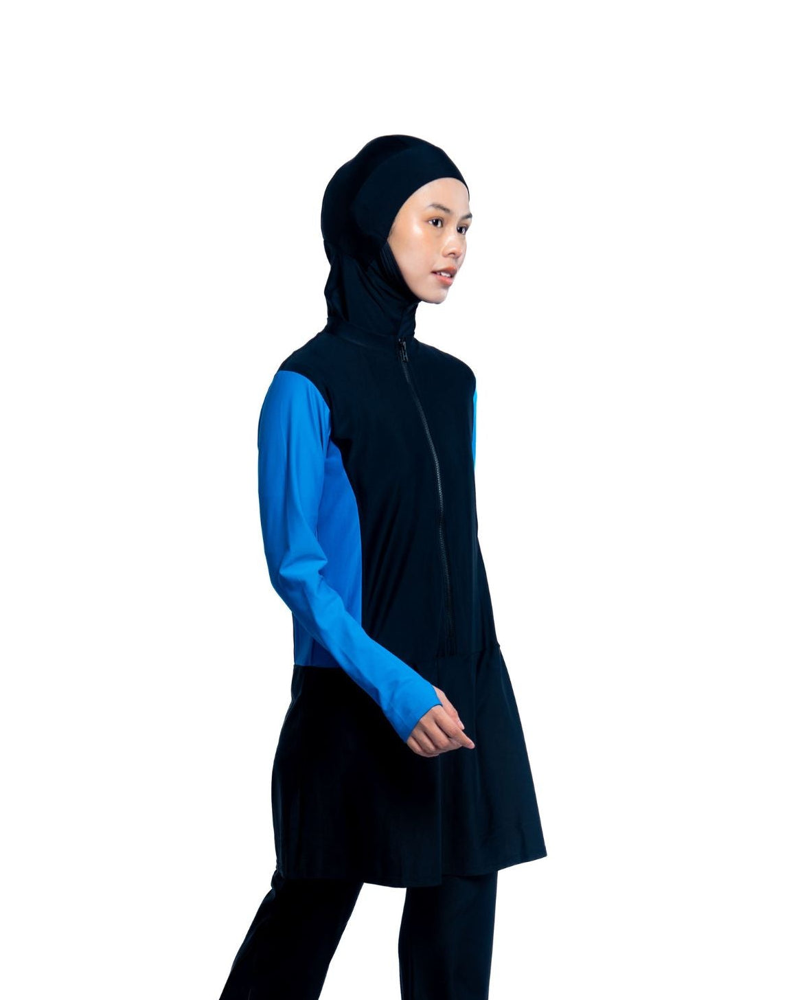Person wearing a black and blue modest swimwear top on a white background